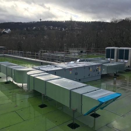 NB Bürogebäude mit KSZE | Ein Dach mit einer großen grünen Fläche und mehreren Klimaanlagen auf der Oberfläche